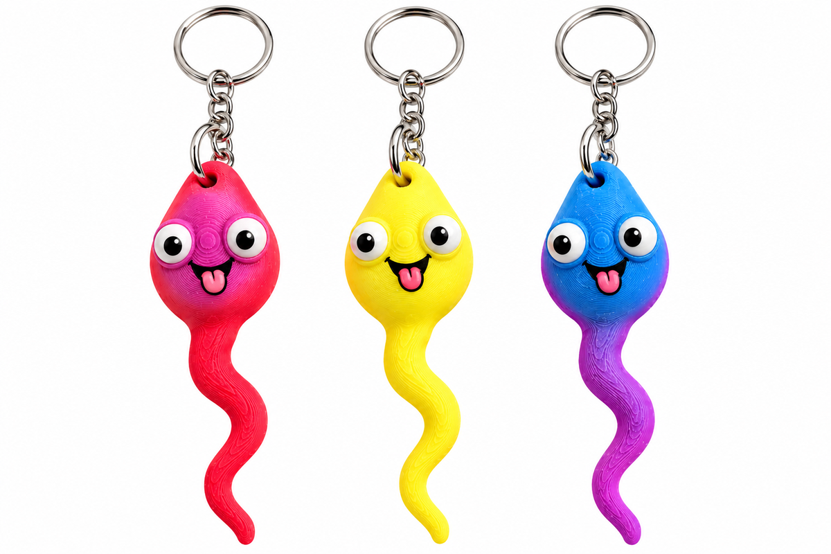 Three novelty sperm-shaped keychains in pink, yellow, and blue-purple, each with cartoon eyes and a wavy tail, shown on a plain white background.