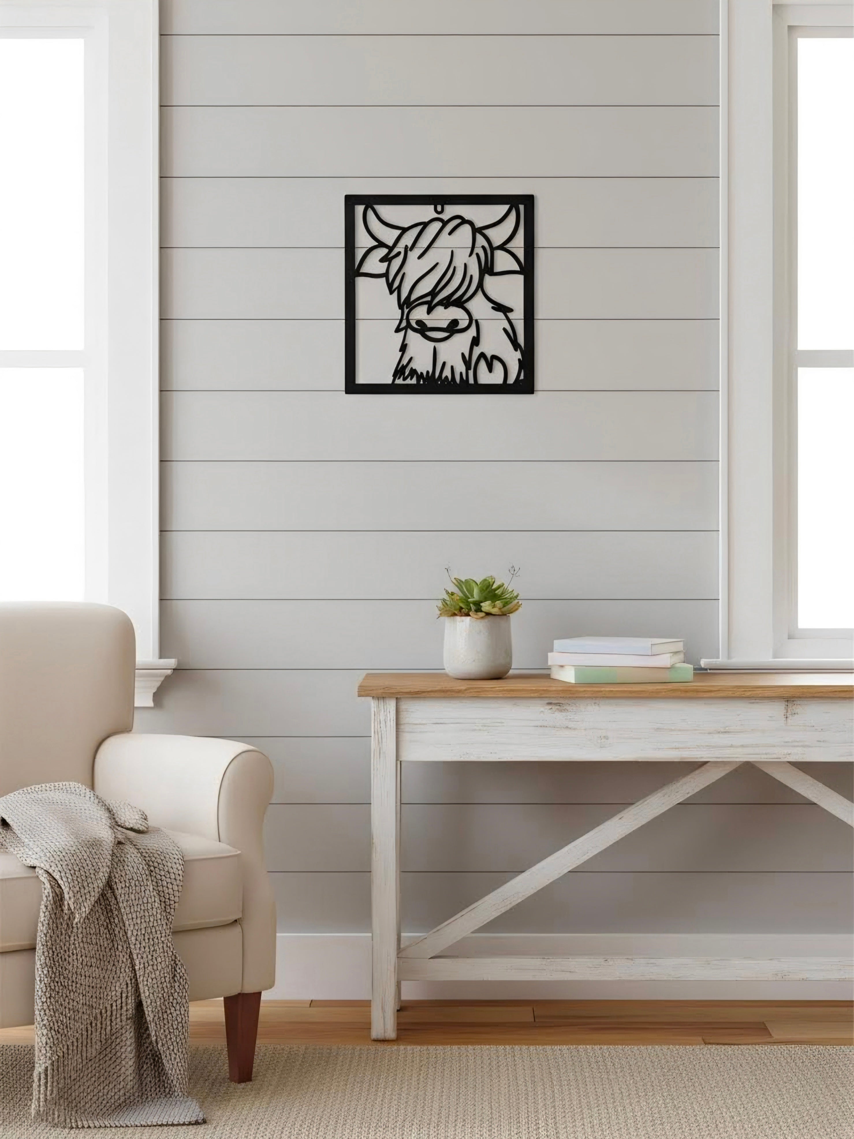 Decorative Line wall art of a Highland Cow in a living room with a white wall and wooden furniture.