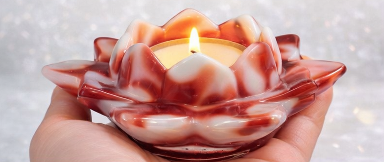 Candle in a shell with a hand holding it against a blurred background