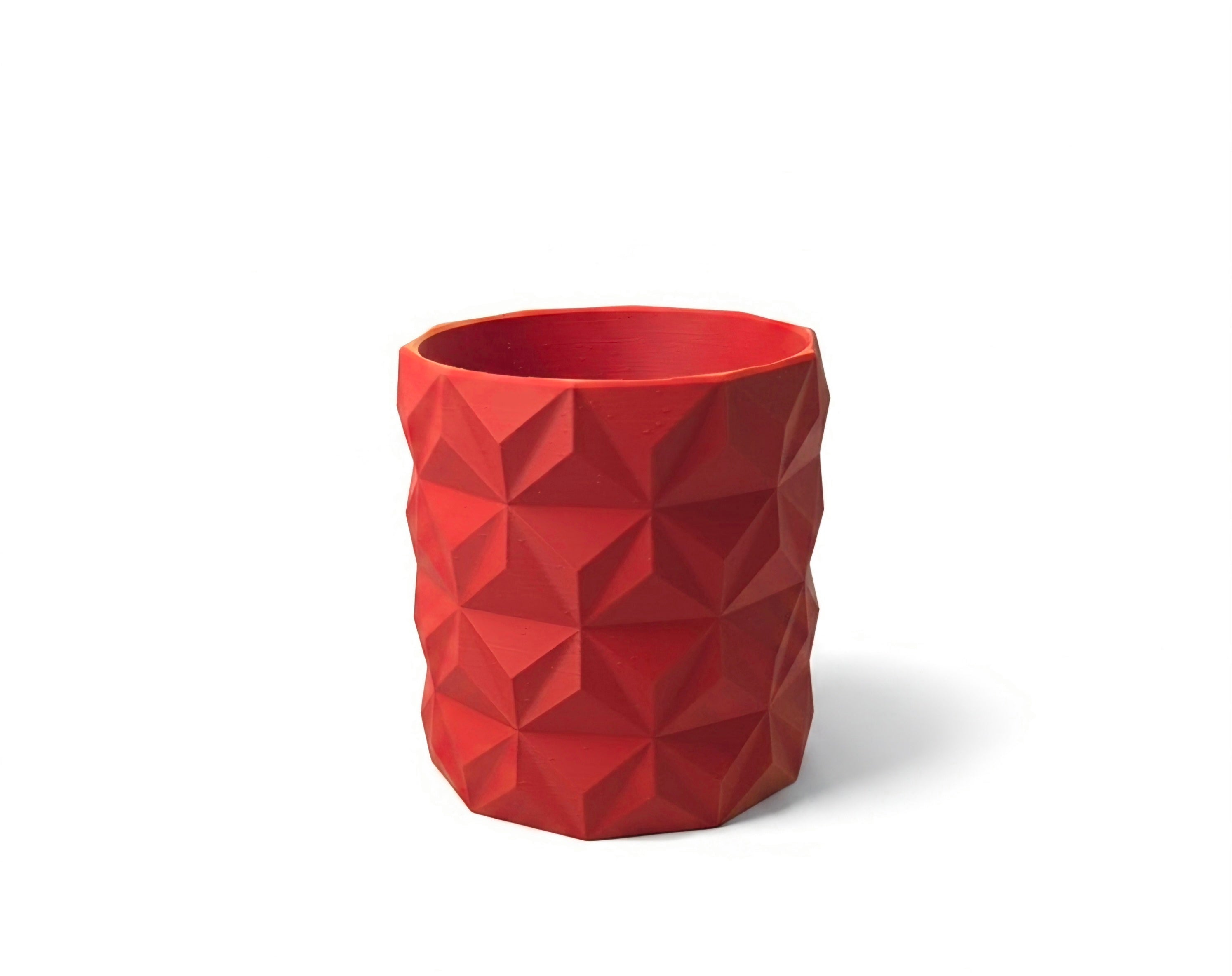 A red textured geometric cup with a faceted, low-poly design, shown on a clean white background with a soft shadow.